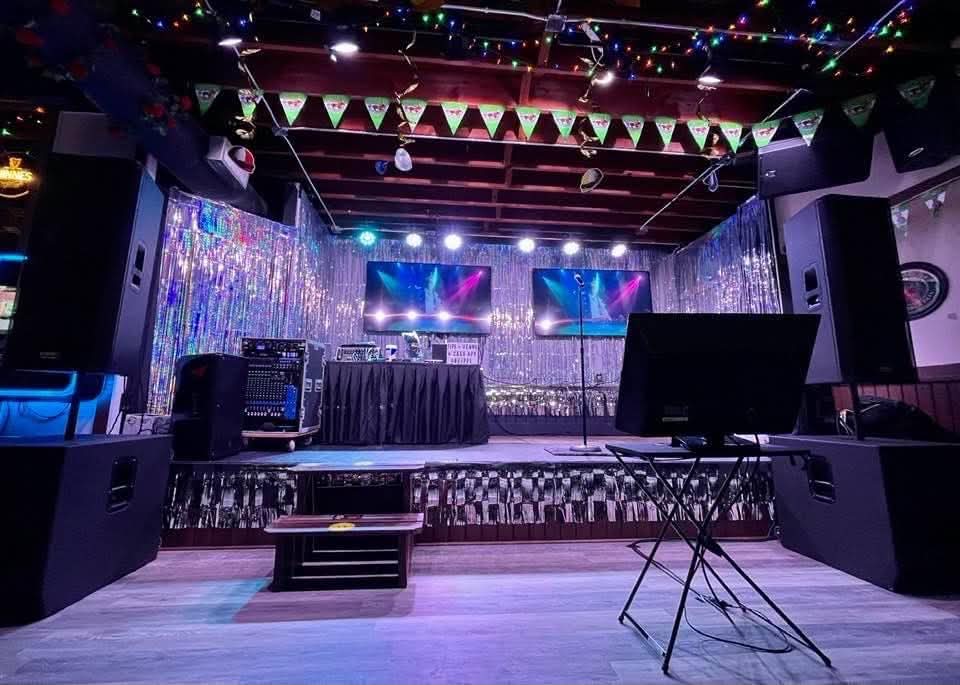 Stage set up with audio equipment and a karaoke display